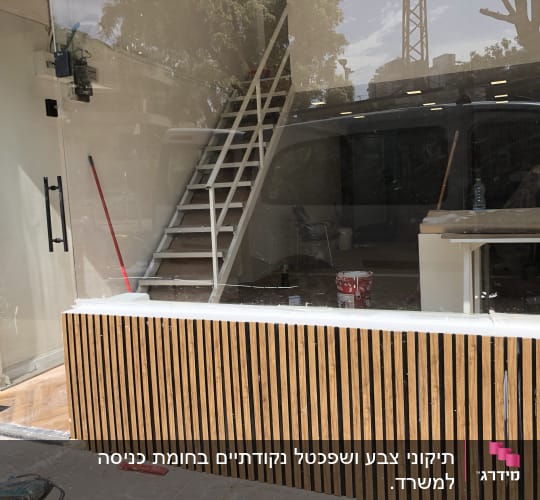 פחית צבע אדומה ומברשת צביעה בחלון ראווה